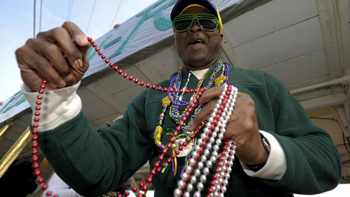 A reveler throws beads at the 2015 North Bay Area Mardi Gras parade in D’Iberville.