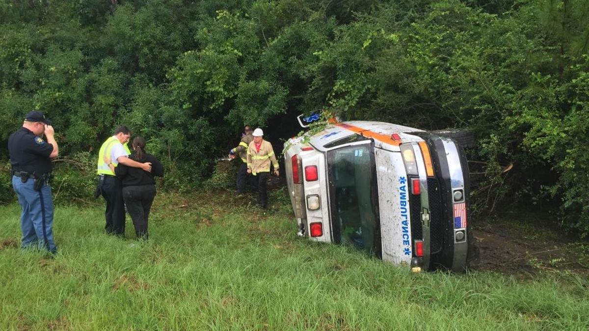 First responders make their way to an ambulance that left the roadway and overturned near the 31 mile marker at Canal Road on Monday, July 11, 2016.