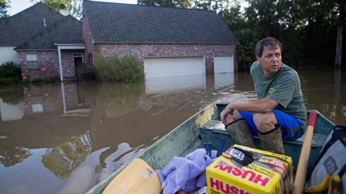 David Key boats away from his flooded home after reviewing the damage in Prairieville, La., on Tuesday, Aug. 16, 2016. Key, an insurance adjuster, fled his home as the floodwater was rising with his wife and three children and returned to assess the damage.