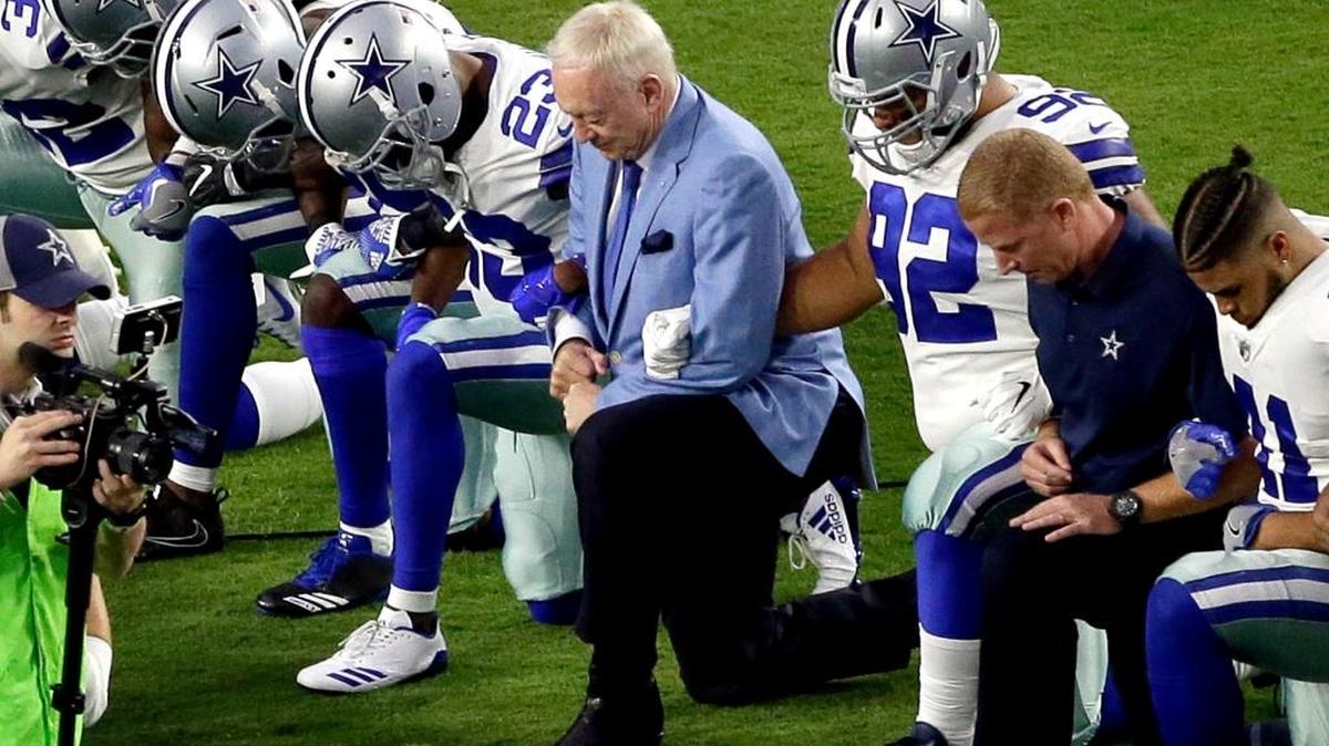 The Dallas Cowboys, led by owner Jerry Jones, center, take a knee Monday prior to the national anthem before an NFL football game against the Arizona Cardinals in Glendale, Ariz. What began more than a year ago with a lone NFL quarterback protesting police brutality against minorities by kneeling silently during the national anthem before games has grown into a roar with hundreds of players sitting, kneeling, locking arms or remaining in locker rooms, their reasons for demonstrating as varied as their methods.