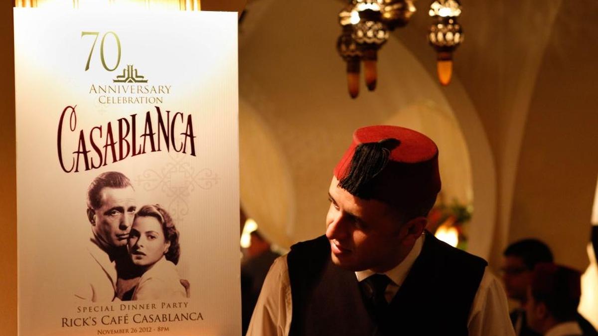 A Rick’s Cafe server looks at the poster announcing the 70th anniversary tribute to the 1942 movie ‘Casablanca’ in Casablanca, Morocco, on Nov. 24, 2012. A former U.S. diplomat spent two years of work and a million dollars in investments to bring Rick’s Cafe to Morocco’s largest city. The elegant nightclub where Humphrey Bogart pined for Ingrid Bergman was just a set on a Warner Bros. sound stage in California, the film crew never got anywhere near North Africa.