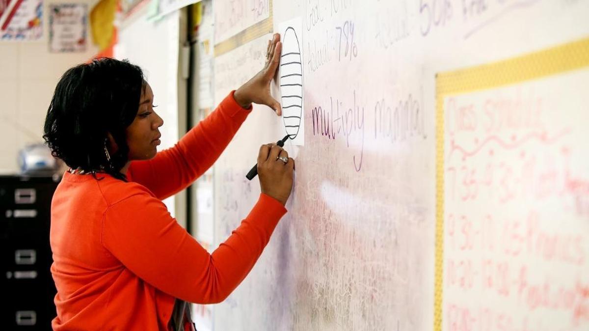 Arlington Elementary School teacher Nadis Chambers helps her second-grade students in April 2017 in Pascagoula. A new funding proposal in the Mississippi Legislature would award state money based on individual students rather than entire districts.
