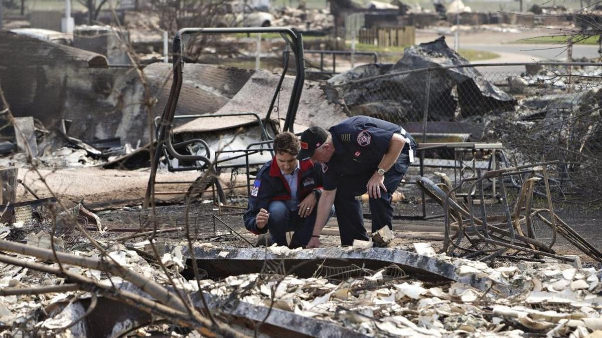 Canadian Prime Minister Justin Trudeau, left, and Fort McMurray Fire Chief Darby Allen look over the devastation during a visit to Fort McMurray, Canada, on May 13.