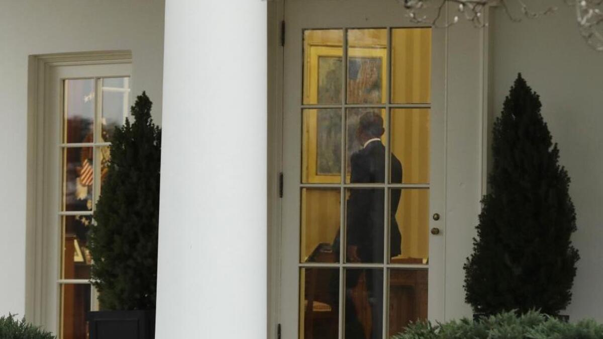 President Barack Obama takes one last look around the Oval Office of the White House on Friday.