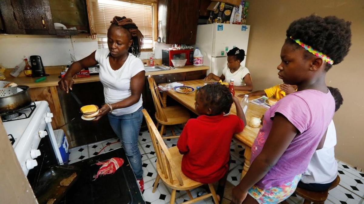 Otibehia Allen prepares dinner July 24 for her children in their rented mobile home in the same isolated, low-income community of Jonestown, where she grew up among the cotton and soybean fields of the Mississippi Delta. Her children are on Medicaid, but Allen says a small pay raise meant she lost her own coverage through the federal and state health insurance program.