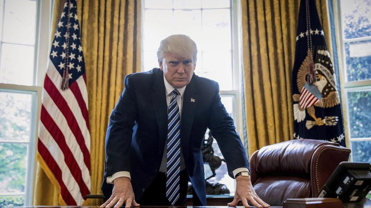 President Donald Trump poses for a portrait in the Oval Office in Washington, Friday, April 21, 2017. With his tweets and his bravado, Trump is putting his mark on the presidency in his first 100 days in office. He's flouted conventions of the institution by holding on to his business, hiring family members as advisers and refusing to release his tax returns. He's tested conventional political wisdom by eschewing travel, church, transparency, discipline, consistency and decorum. But the presidency is also having an impact on Trump, prompting him, at times, to play the role of traditional president.