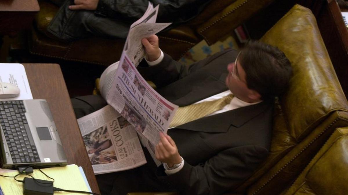 District 113 representative Hank Zuber reads the paper before Legislative session starts.
