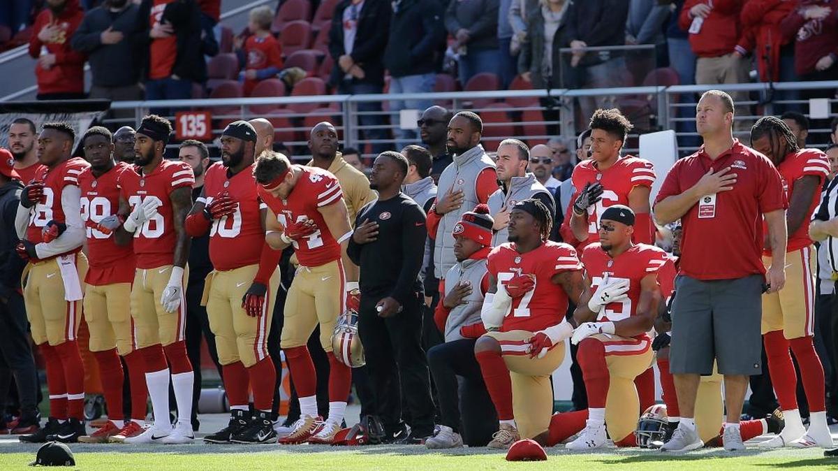 San Francisco 49ers outside linebacker Eli Harold, center kneeling, and safety Eric Reid right kneeling, kneel during the national anthem before an NFL football game between the 49ers and the Arizona Cardinals in Santa Clara, California, on Sunday, Nov. 5, 2017.