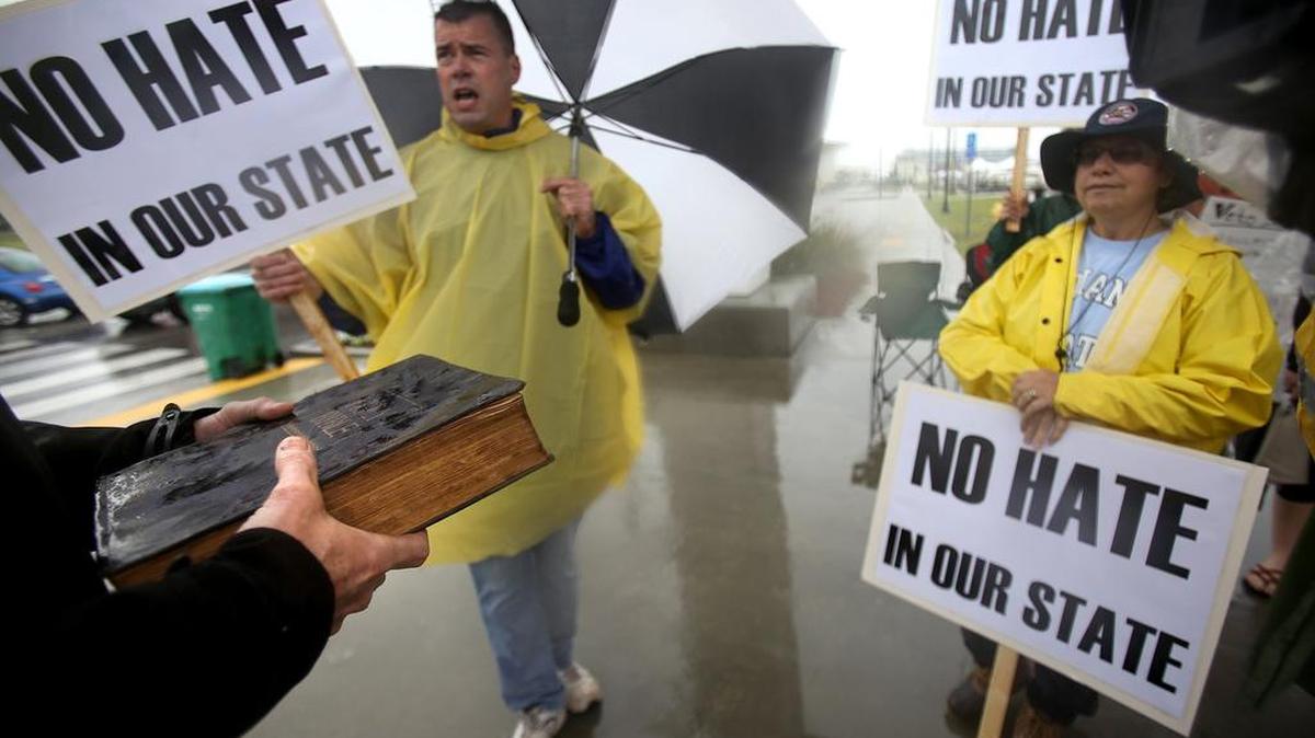 HB 1523 supporter William Young, left, holds his family Bible while arguing with a group gathered to protest the bill at Jones Park on Wednesday, April 13, 2016.