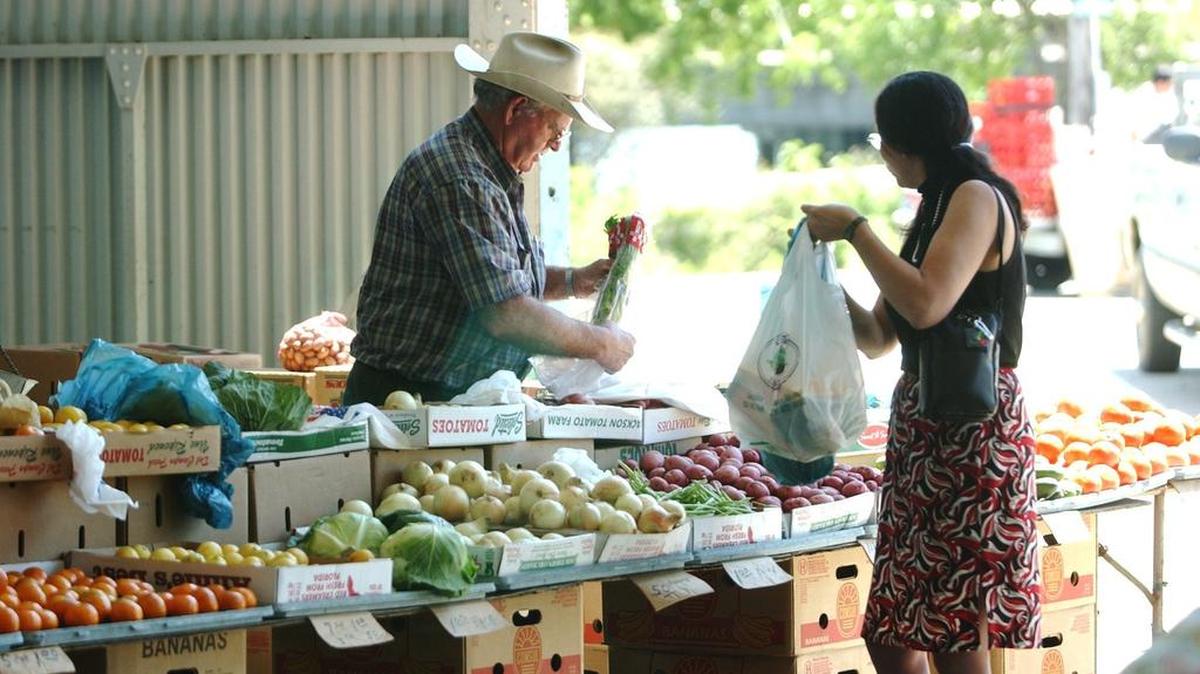 Vendor W. E. David, left, makes a sale to customer J. D. Lee during her lunch break Tuesday as the Farmer’s Market held grand opening day for this year’s season at Point Cadet Plaza in Biloxi. A Sound Off contributor asks Biloxi to help the market with promotion and better signage.