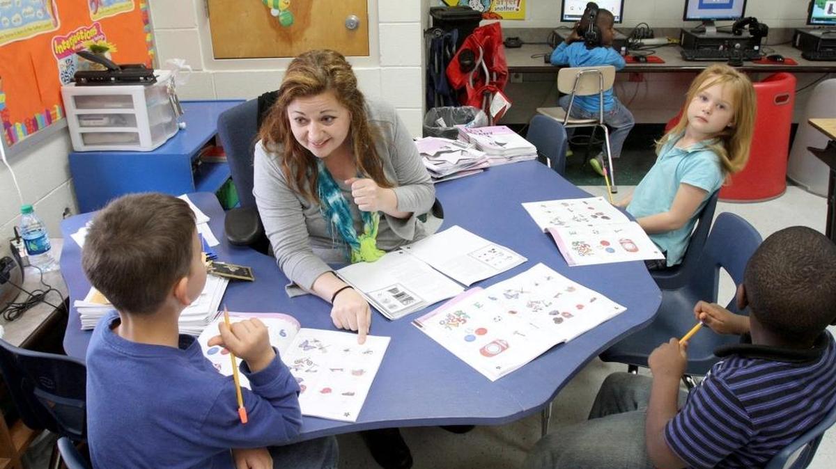 Julie Bass works with students at Popps Ferry Elementary School in Biloxi in 2015.