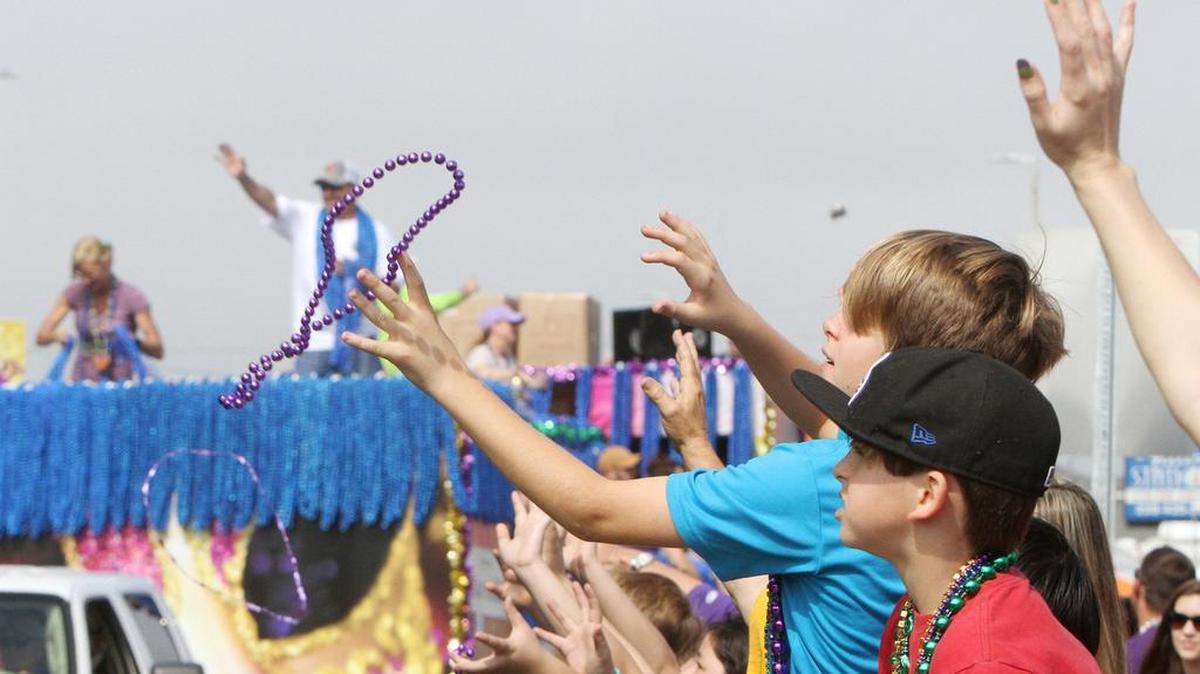 A reveler catches beads during the Gulf Coast Carnival Association Mardi Gras parade in Biloxi on Tuesday, Feb. 28, 2017.