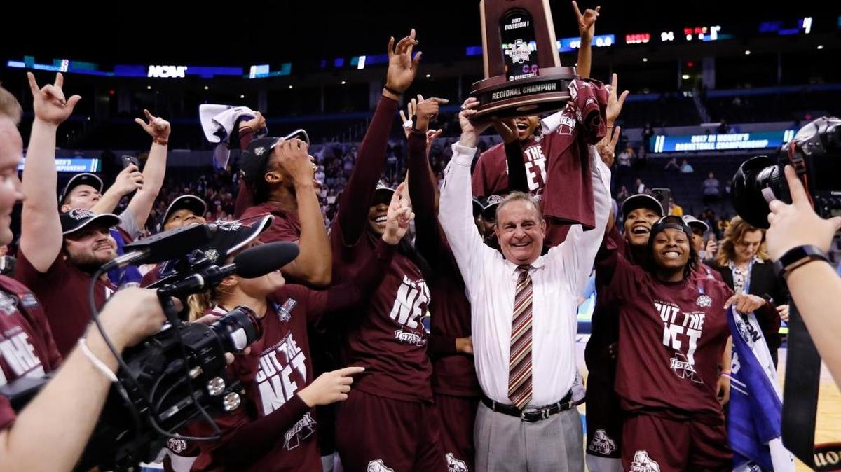 Mississippi State head coach Vic Schaefer holds up the championship trophy as he celebrates with his team after a regional final of the NCAA women's college basketball tournament against Baylor, Sunday, March 26, 2017, in Oklahoma City. Mississippi State won 94-85.