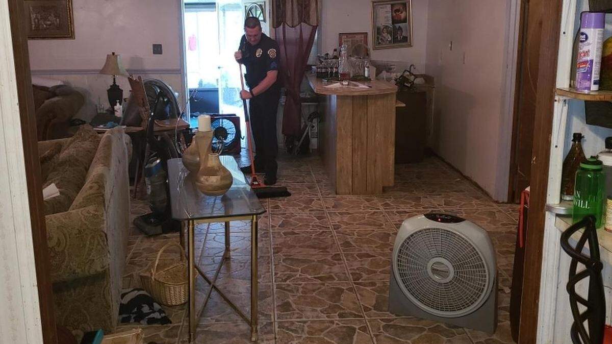 Sgt. Lancen Shipman, shift supervisor at Moss Point police, helps with the cleanup on Thursday. The woman was in a panic with a flooded house, when officers arrived, he said.