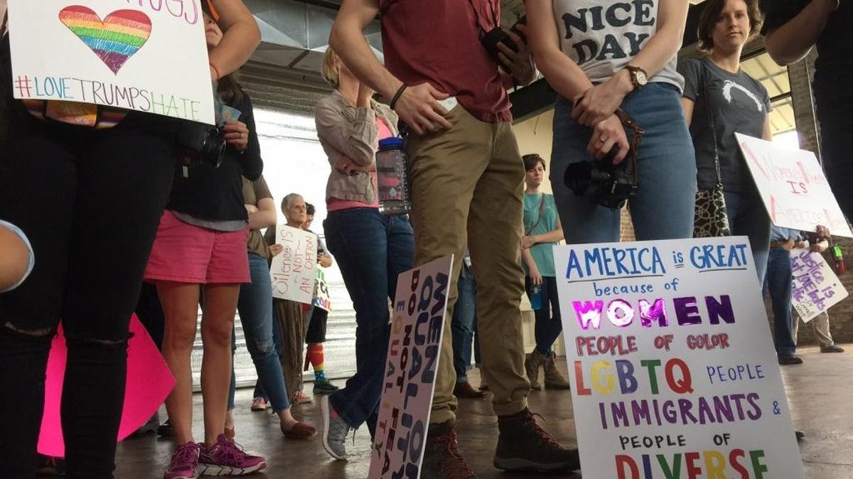 People hold signs at the Gulf Coast Solidarity Rally before the Women’s March at Cafe Climb in Gulfport on Saturday, Jan. 21, 2017.