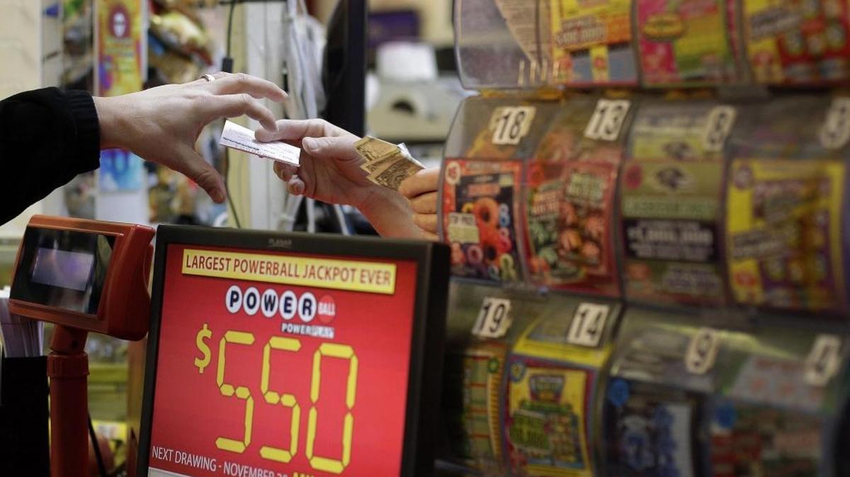 A customer, left, reaches for a Powerball ticket that he purchased in a convenience store in Baltimore, Wednesday, Nov. 28, 2012.