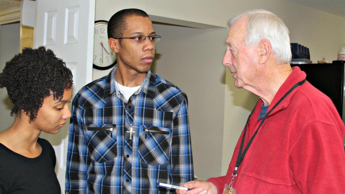 Ted Hearn, right, a coordinator at the Salvation Army cold weather shelter in Gulfport, works with Ieshia Smith, left, and Ryheen Brown. The college students said they saw on Facebook that shelter volunteers were needed.