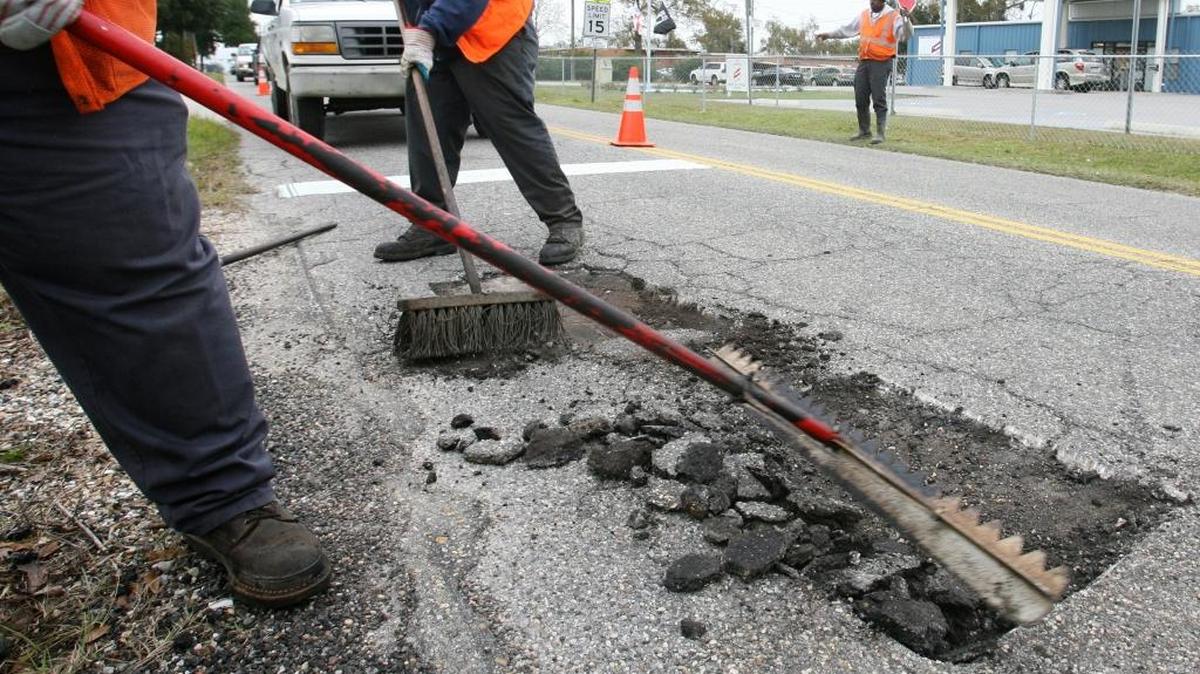 JOHN FITZHUGH/SUN HERALD
City of Gulfport employees Michael Daniels, from left, Marcus Corbett and Bobby Lewis patche potholes on Dedeaux Road on Thursday.
