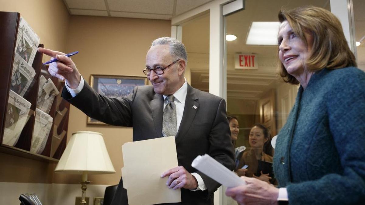 Senate Minority Leader Chuck Schumer (D-N.Y.) and House Minority Leader Nancy Pelosi (D-Calif.) review notes before a news conference on Capitol Hill in Washington, March 22, 2018. The House on Thursday gave swift approval to a $1.3 trillion spending bill that would fund the government through September, shaking off the objections of its most conservative members and voting less than 24 hours after the 2,232-page document was unveiled.