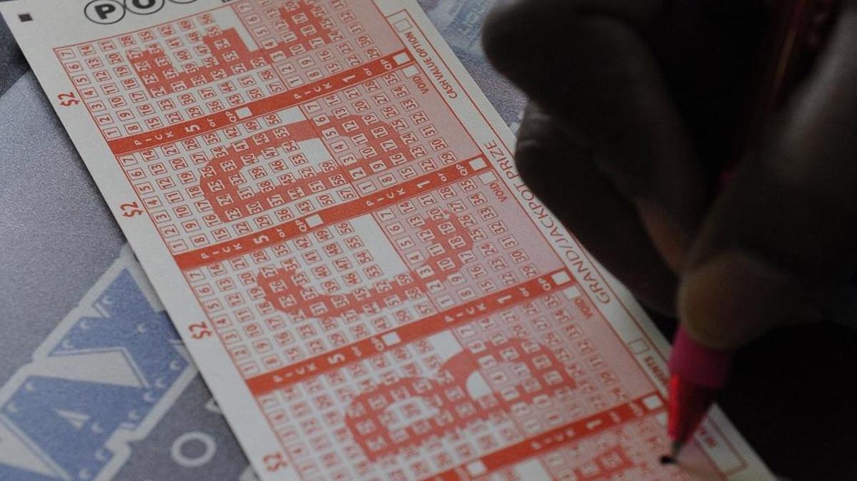A customer fills in his numbers on a Powerball ticket for a chance to win the $450,000 jackpot Monday, Nov. 26, 2012, in Houston.