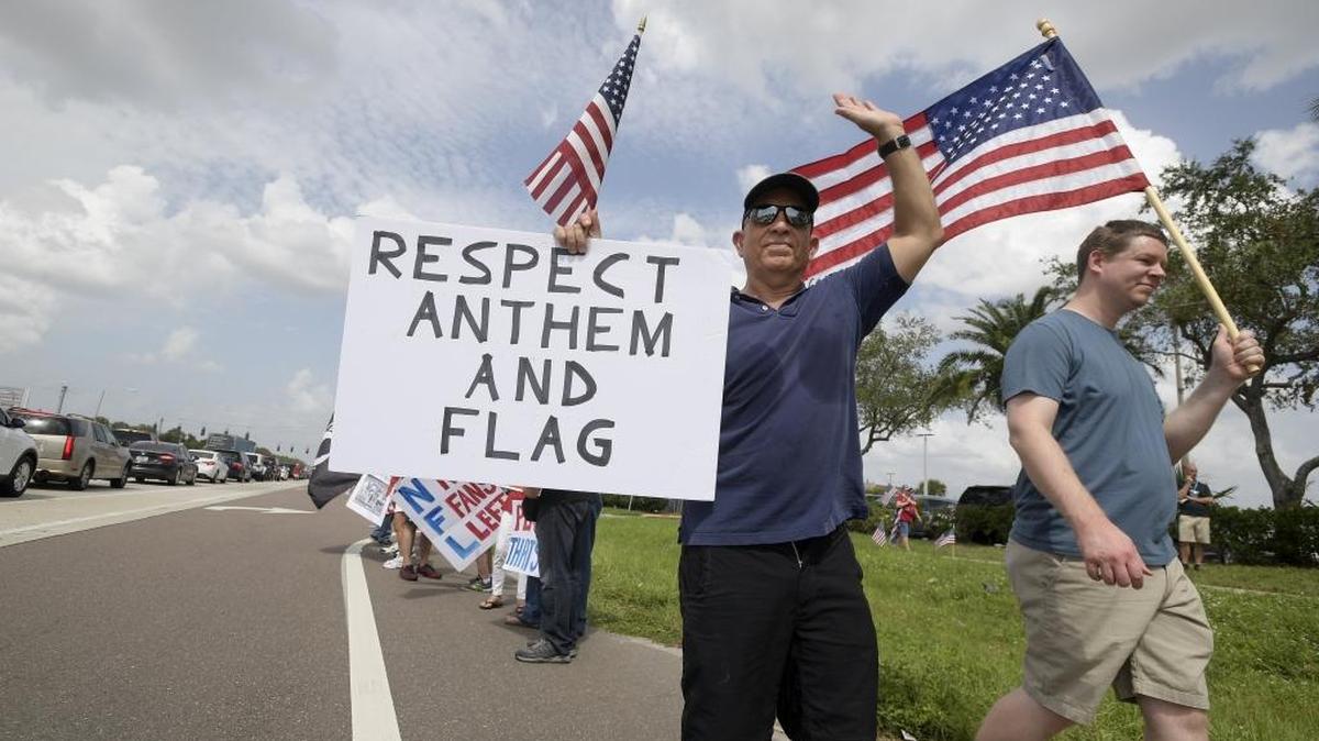 Protesters upset with players kneeling during the national anthem stand along a road leading to Raymond James Stadium before an NFL football game between the Tampa Bay Buccaneers and the New York Giants Sunday, Oct. 1, 2017, in Tampa, Fla.