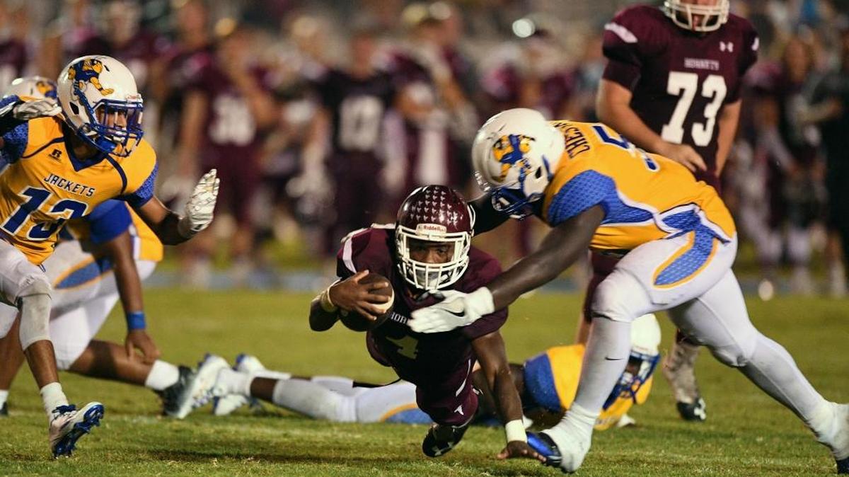East Central running back Tony Brown (4) carries the ball against St. Martin defenders Kelvin Chestang (right) and Blake Palmer (left) during the second quarter Friday at East Central High School in Hurley, Miss.
