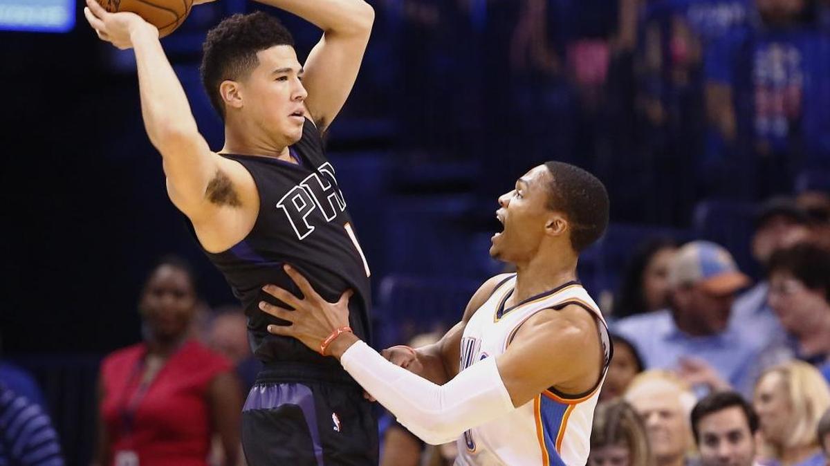 Phoenix Suns guard Devin Booker, left, looks to pass as Oklahoma City Thunder guard Russell Westbrook defends during the first quarter of an NBA basketball game in Oklahoma City on Oct. 28.