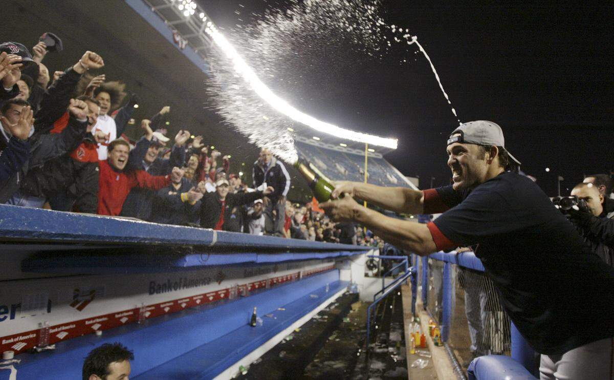 Boston Red Sox's Doug Mientkiewicz, right, sprays champagne on Boston fans after Boston defeated the New York Yankees 10-3 in the final game of the AL championship series Wednesday, Oct. 20, 2004, in New York.