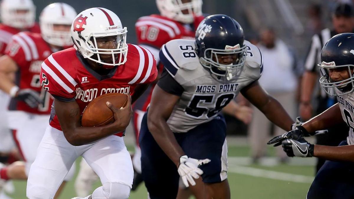 Harrison Central quarterback Tavis Williams, left, runs the ball against Moss Point on Friday, September 2, 2016, in Harrison County.