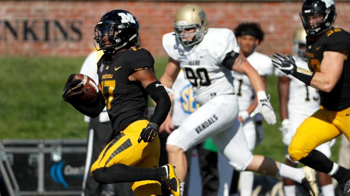 Missouri's Richaud Floyd, left, slips past Idaho's Zach Cable (90) on his way to an 85-yard punt return for a touchdown.