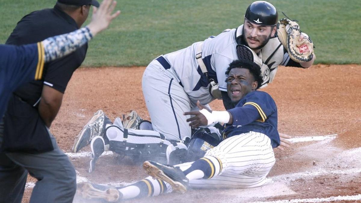 MGCCC second baseman Marcus Buckley and St. Louis catcher David Prost plead their case as the umpire signals Buckley safe. Photographer's Comment - I like the action at the plate and the lobbying for the umpire's call. The two dynamics playing against each other made for a nice image.