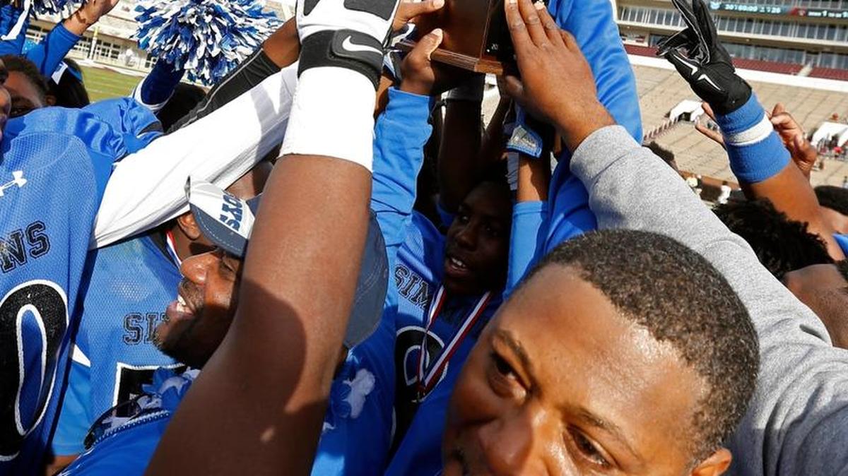 Simmons' football coach Tavares Johnson tears up as his team passes around the trophy after winning the Class 1A football championship game over Lumberton 30-26.