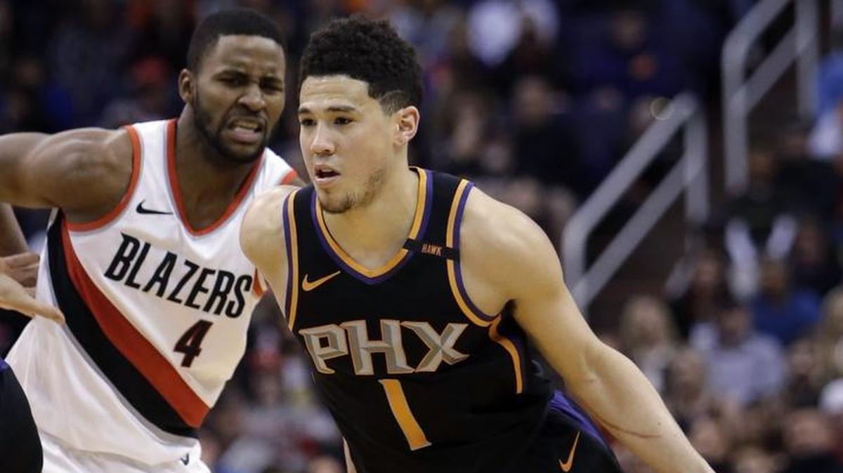 Phoenix Suns guard Devin Booker (1) drives past Portland Trail Blazers forward Maurice Harkless during the second half a game Saturday in Phoenix.