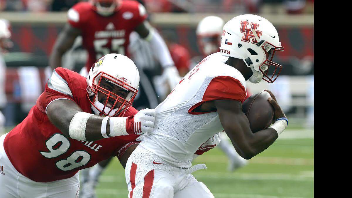 Louisville's Sheldon Rankins (98) attempts to bring down Houston's Greg Ward Jr. during the first half of an NCAA college football game in Louisville, Ky., Saturday, Sept. 12, 2015