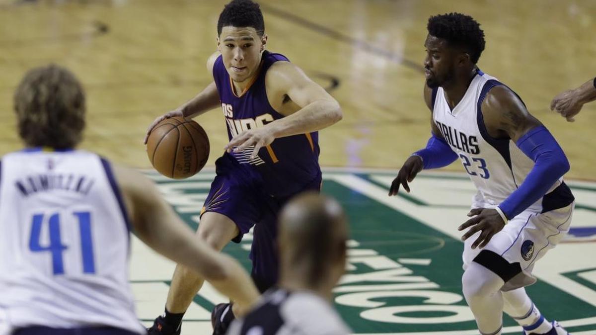 Phoenix Suns Devin Booker drives the ball past Wesley Matthews of the Dallas Mavericks in Mexico City on Jan. 12.
