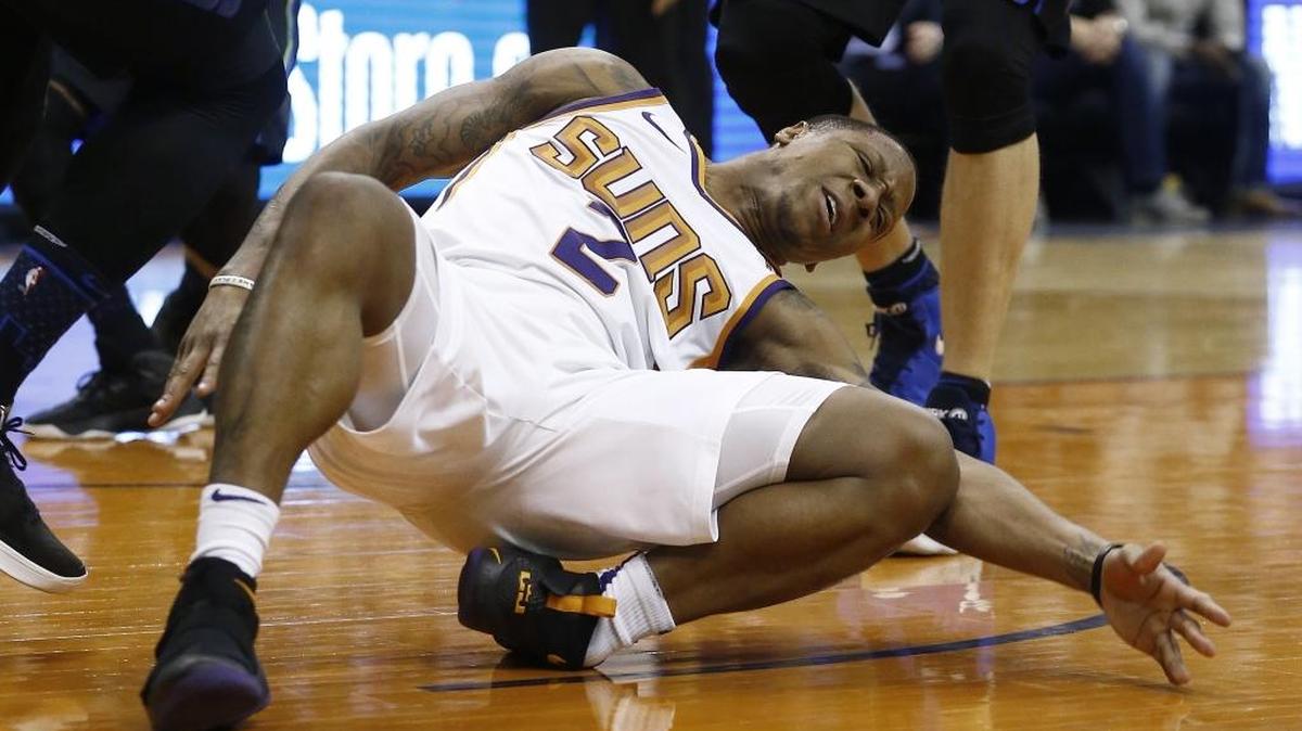Phoenix Suns guard Isaiah Canaan injures his foot, landing awkwardly, after being fouled against the Dallas Mavericks during the first half of an NBA basketball game, Wednesday in Phoenix. The Suns defeated the Mavericks 102-88.
