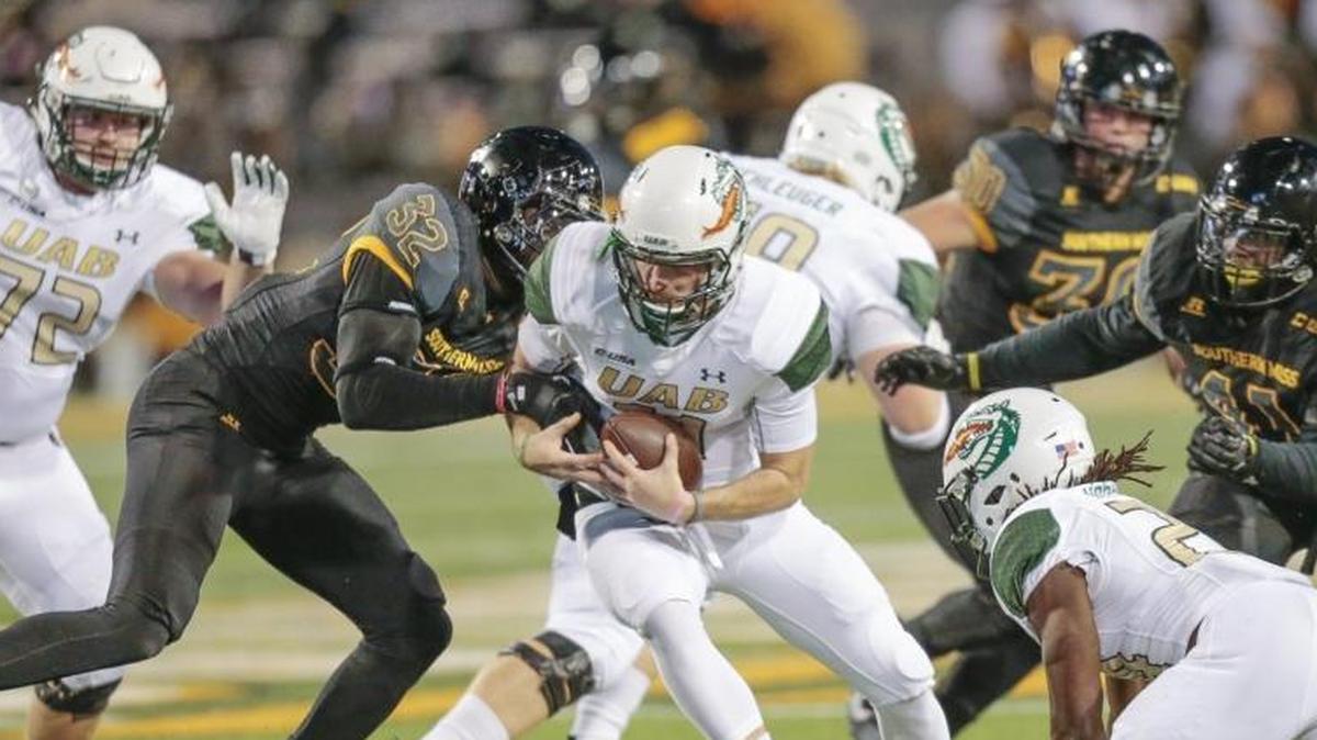 Southern Miss defensive lineman Xavier Thigpen (32) tackles UAB quarterback A.J. Erdely during the game at Roberts Stadium in Hattiesburg on Oct. 28.