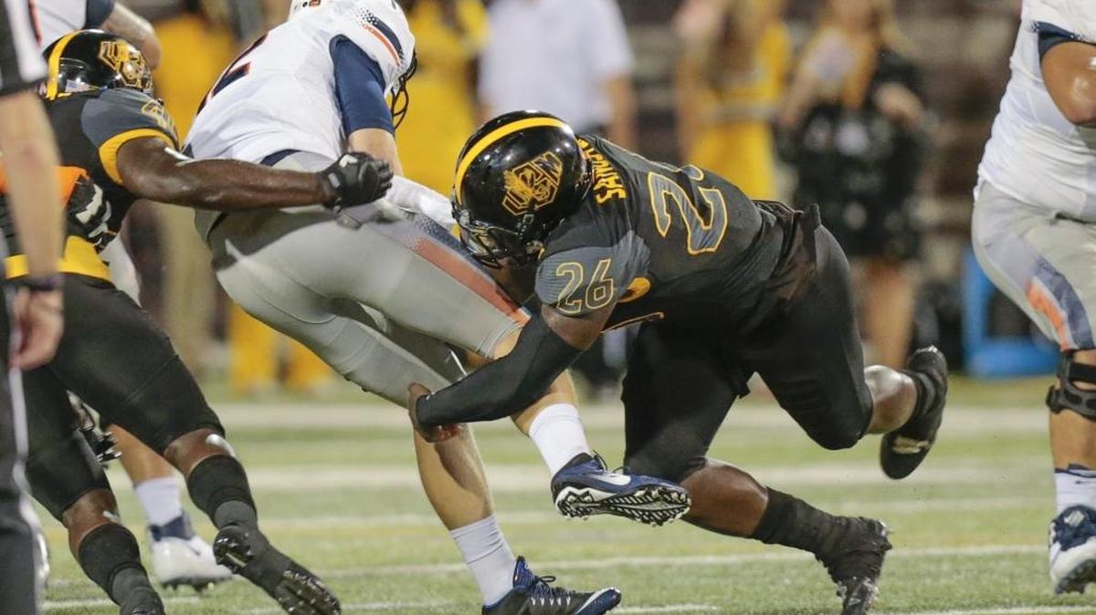 Southern Miss linebacker Jeremy Sangster (26) sacks UTEP quarterback Zack Greenlee (8) during the game Saturday in Hattiesburg.