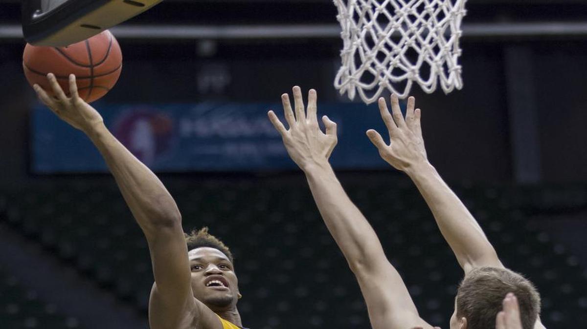 Southern Mississippi guard Cortez Edwards, left, shoots layup over Stephen F. Austin forward Samuli Nieminen (24).