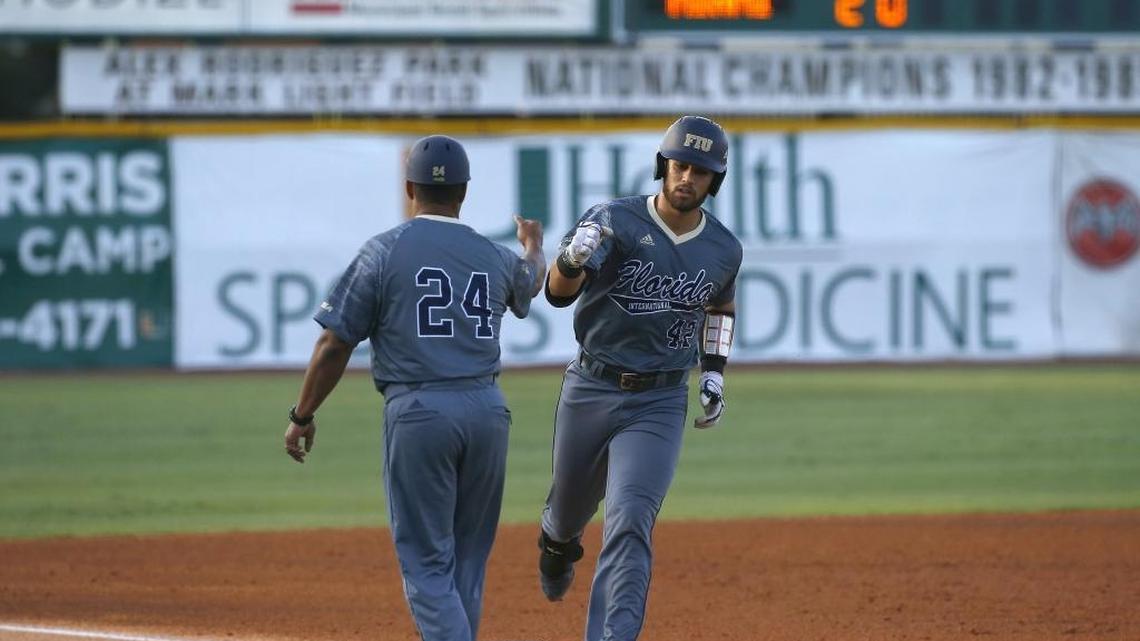 FIU Panthers JC catcher Escarra is congratulated by head coach Mervyl Melend on his solo home run April 26 in Coral Gables.