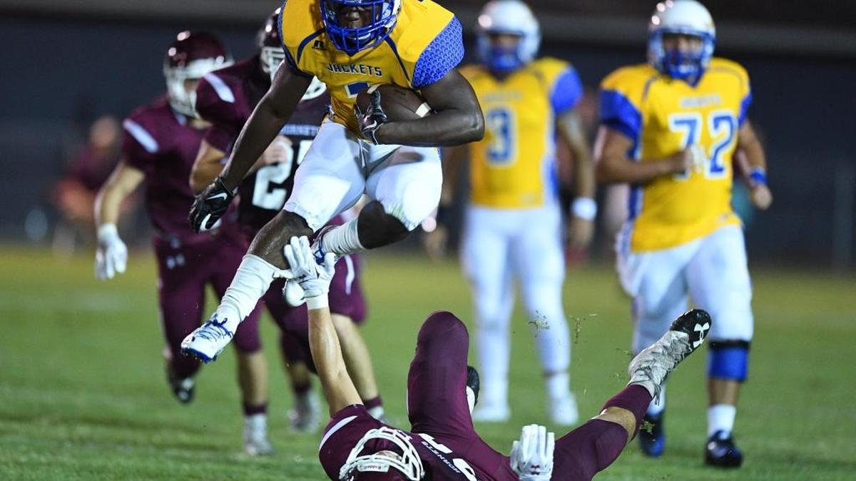 St. Martin's Ham Mcgee (1) leaps over East Central defensive back Andrew Seward (26) on a carry during the first quarter on Sept. 16 at East Central High School in Hurley.