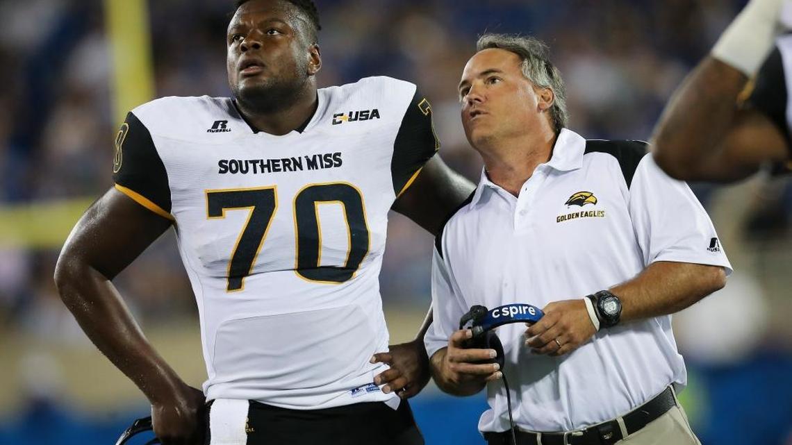 Southern Miss head coach Jay Hopson and offensive lineman Cameron Tom watch a replay in the second half against Kentucky Saturday in Lexington, Ky. Southern Miss won the game 44-35.