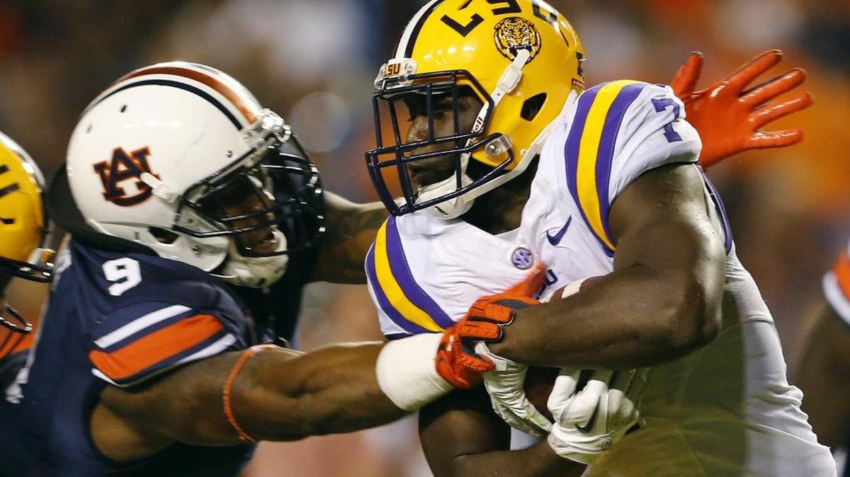 LSU running back Leonard Fournette (7) carries the ball as Auburn defensive end Byron Cowart (9) tries to tackle him on Sept. 24 in Auburn, Ala.