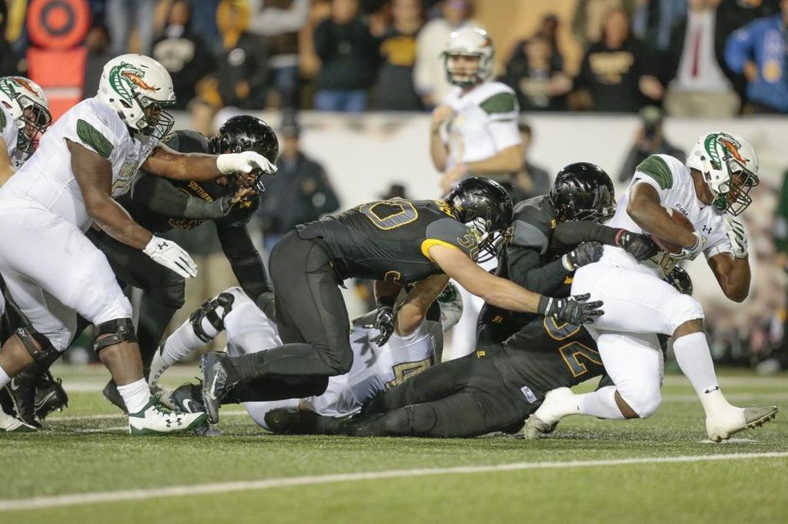 Former UAB running back Spencer Brown (28) tries to escape Southern Miss defensive lineman Xavier Thigpen (32) during the game at M.M. Roberts Stadium Saturday.