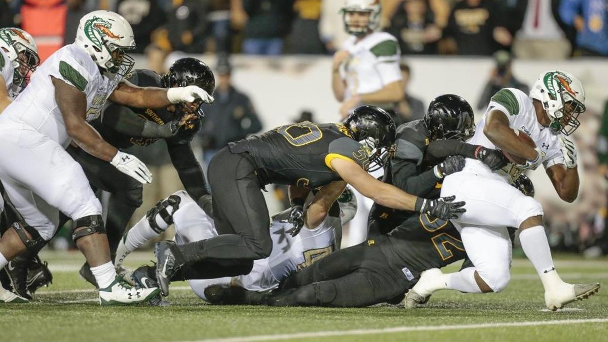 UAB running back Spencer Brown (28) tries to escape Southern Miss defensive lineman Xavier Thigpen (32) during the game at M.M. Roberts Stadium on Saturday.