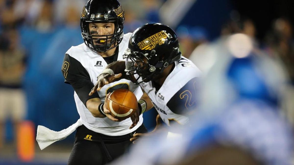 Southern Miss quarterback Nick Mullens hands the ball off to running back George Payne against Kentucky Saturday in Lexington, Ky. Southern Miss won the game 44-35.