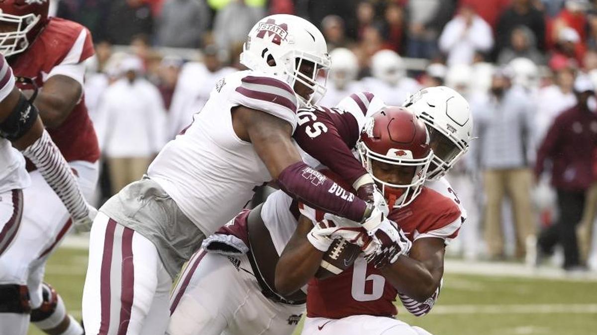Arkansas receiver T.J. Hammonds is tackled by Mississippi State defenders Gerri Green (left) and Cory Thomas on Saturday in Fayetteville, Ark.