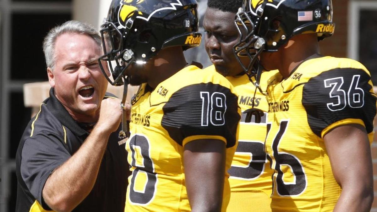 Southern Miss head coach Jay Hopson talks to his captains before their game against Kentucky at M.M. Roberts Stadium in Hattiesburg on Sept. 2.