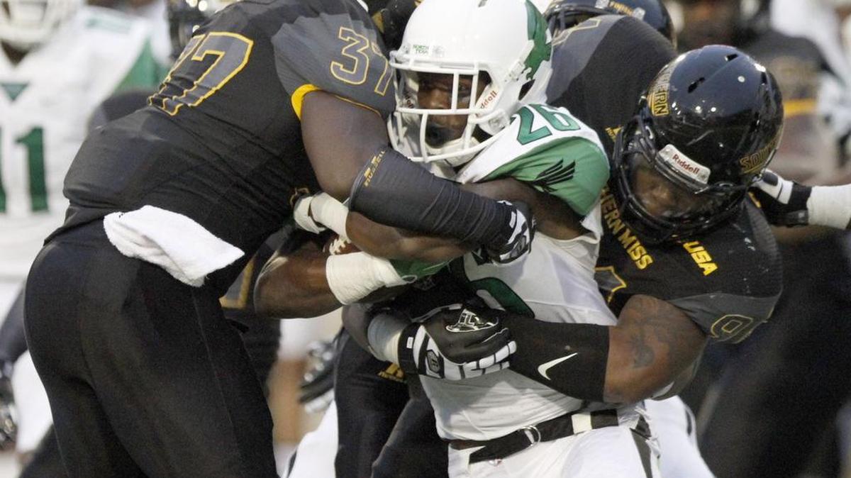 North Texas running back Jeffrey Wilson is brought down by Southern Miss defenders Dylan Bradley and Sherrod Ruff on Oct. 3, 2015, in Hattiesburg.
