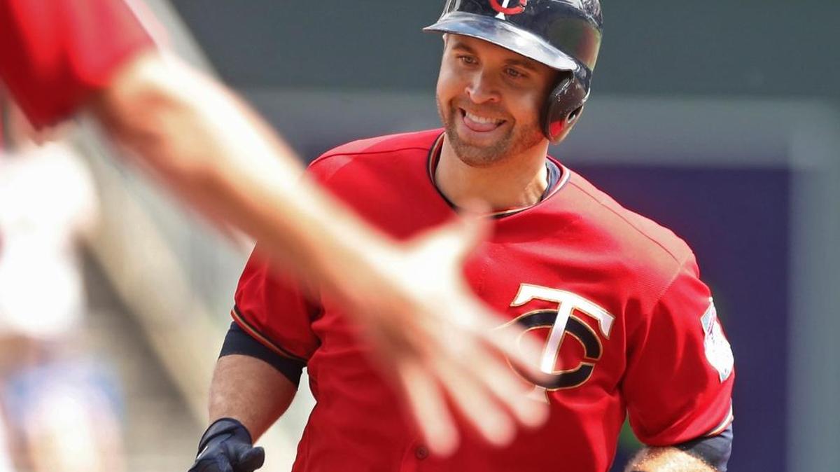 Minnesota Twins' Brian Dozier smiles as the third base coach reaches out to congratulate him as he jogs the base path on a solo home run off Kansas City Royals pitcher Ian Kennedy in the first inning Monday Minneapolis.